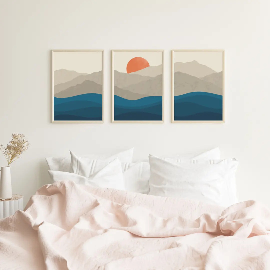 Set of 3 landscape artworks hanging above a bed